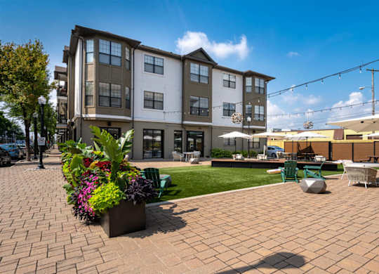 A large multi-story building with a patio in front of it.