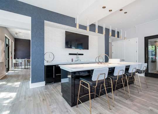 A modern kitchen with a white countertop and black cabinets.
