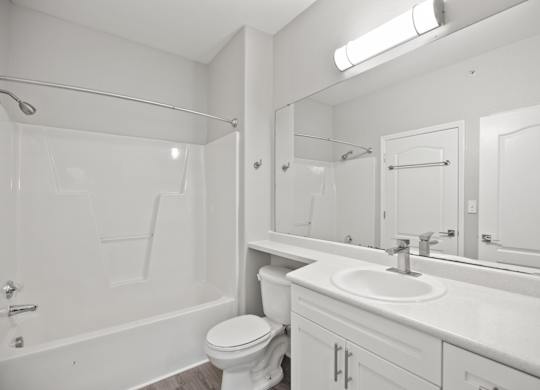 A white bathroom with a toilet, sink, and bathtub.