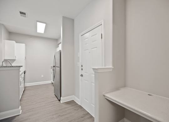 A kitchen with white cabinets and a refrigerator.