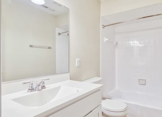 A white bathroom with a sink, toilet, and bathtub.