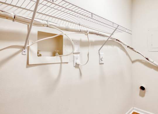 A white wall with a metal shelf and a hole in it.