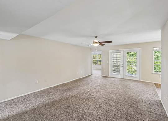 A room with a ceiling fan and carpeted floor.