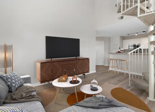 a living room with a tv and a spiral staircase at Orleans Apartments, Columbus, 43221