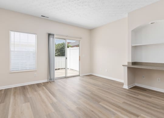 an empty living room with a sliding glass door to a patio  at Orleans Apartments, Ohio