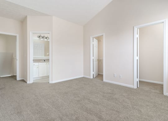 an empty living room with white walls and carpet