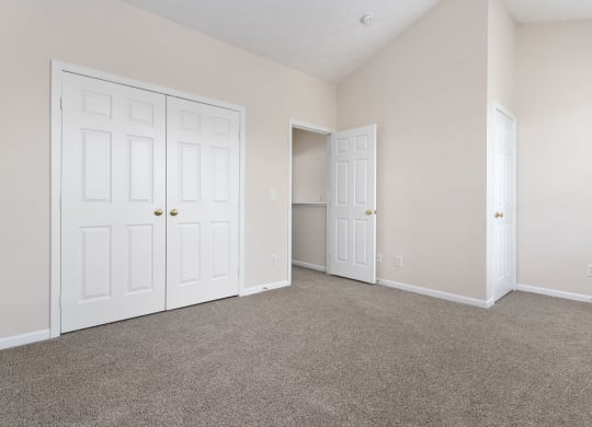 an empty bedroom with two closets and two doors at Orleans Apartments, Columbus, 43221