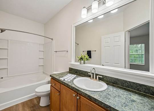 A bathroom with a marble countertop and a white toilet.
