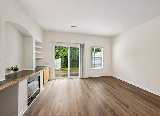 A kitchen with a wooden floor and a window.