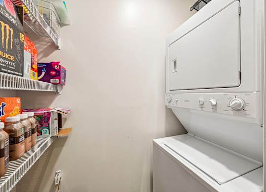 A white microwave oven is placed in a kitchen pantry.