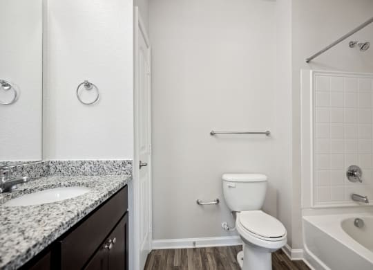 a bathroom with a toilet and a sink and a bath tub