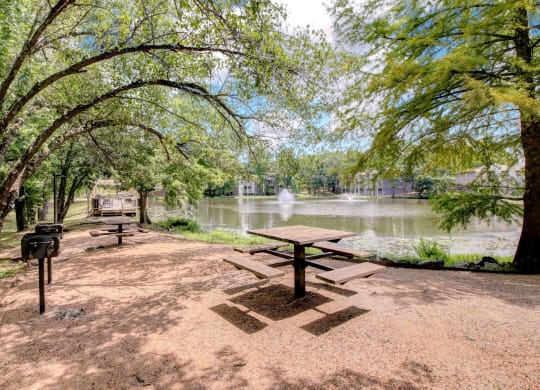 a picnic area with a picnic table next to a lake