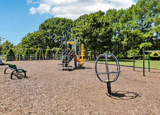 A playground with a swing set and a seesaw.