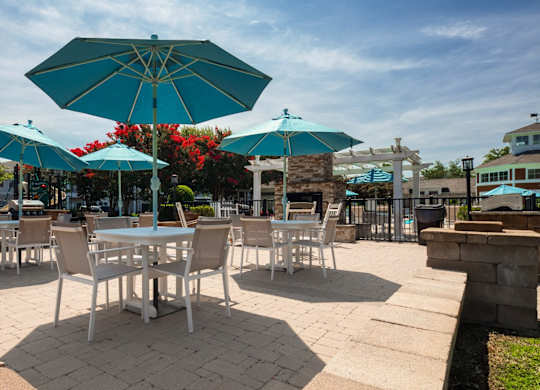 A patio with tables and chairs under umbrellas.
