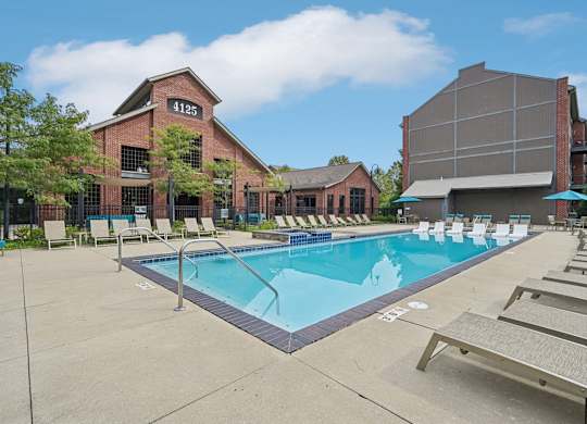 A pool with sun loungers and a building with the number 41125 on it.