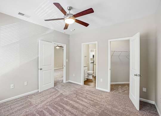 A room with a ceiling fan and carpeted floor.