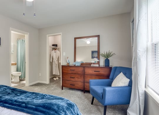 a bedroom with a bed and a dresser and a bathroom