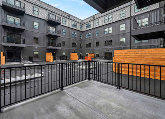 A black and white building with a balcony and a black fence.