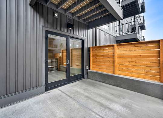 A modern building with a wooden fence and glass doors.