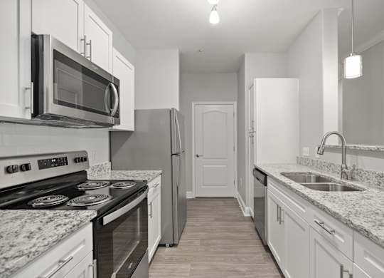 A kitchen with a black stove top oven and a black microwave above it.