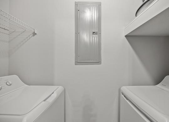 A white washing machine and dryer in a small laundry room.
