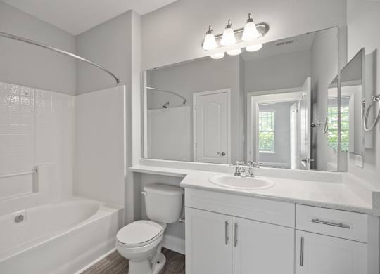 A white bathroom with a toilet, sink, and bathtub.