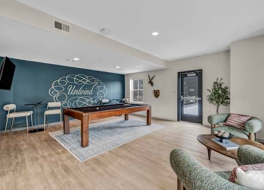 A living room with a pool table and a couch.