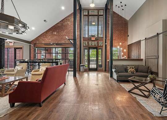 A living room with a red couch and a wooden floor.