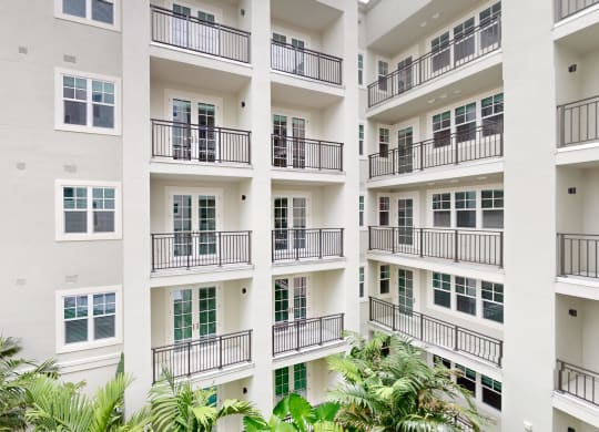 a large apartment building with balconies and palm trees