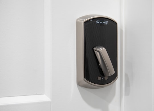 a black remote control door handle on a white door