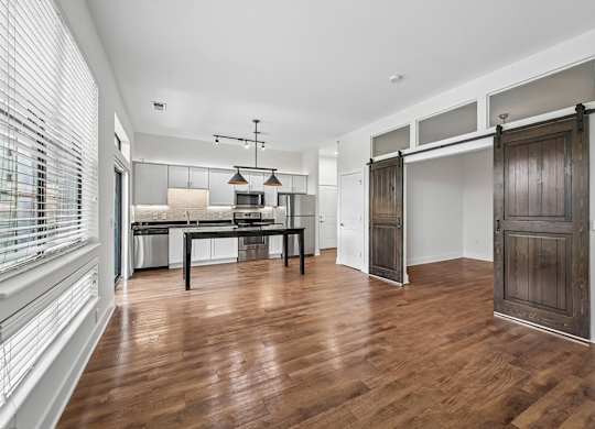 A room with a wooden floor and a table with chairs.