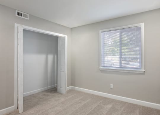 a bedroom with a large window and a closet