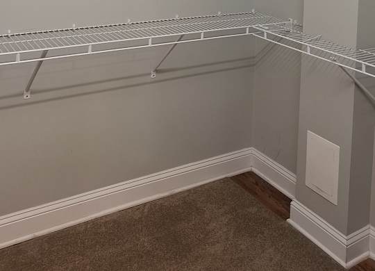 an empty closet in a room with a shelf on the wall