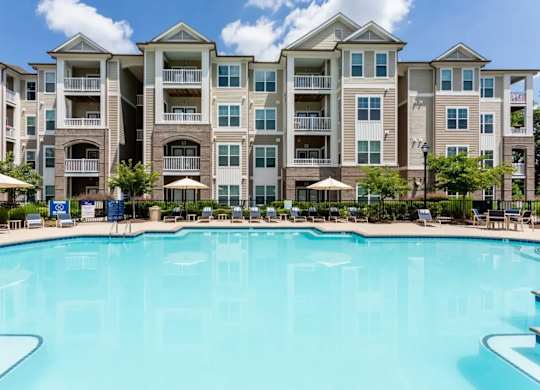A large swimming pool in front of apartment buildings.