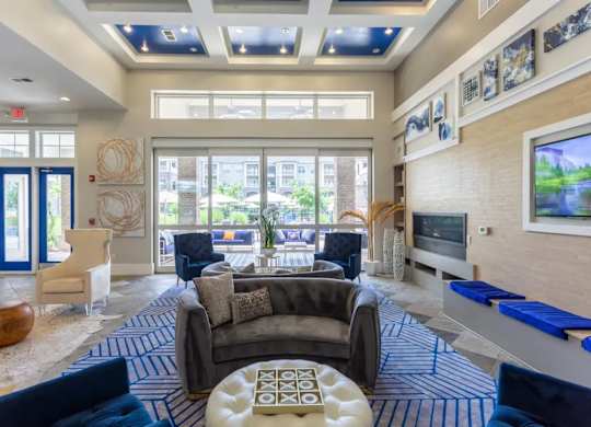 A living room with a blue and white rug and a large window.