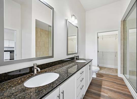 A bathroom with a sink, mirror, and shower.