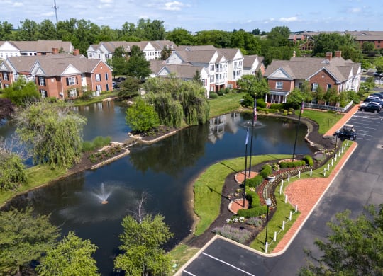 an aerial view of a pond with houses in the background at The Charleston, Columbus, OH