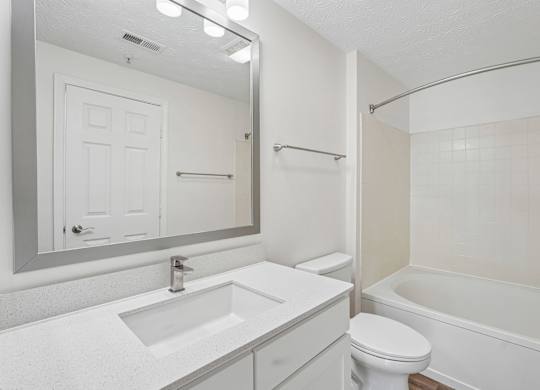 A white bathroom with a sink, toilet, and bathtub.