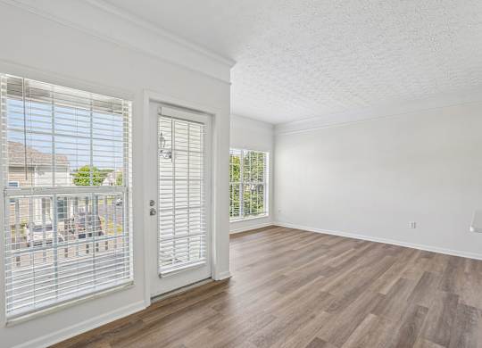 A room with a white door and a window with blinds.
