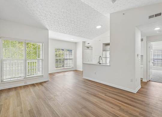 A spacious room with wooden floors and white walls.