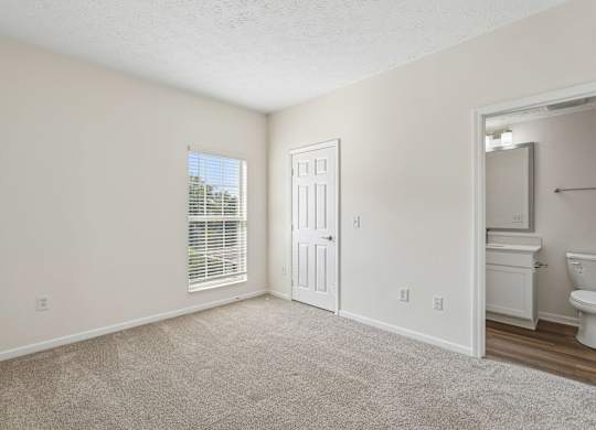 A room with a carpeted floor and a white door.