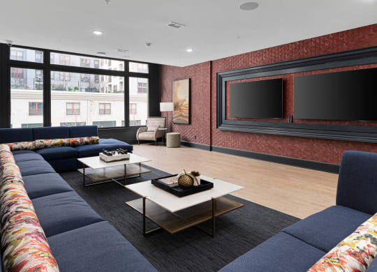 a large living room with blue couches and a large television at The Madison, Columbus, Ohio
