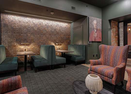 A room with a brick wall and a row of chairs.