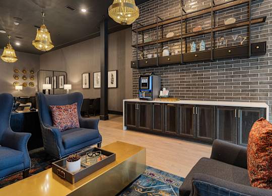 A living room with a blue chair and a black couch.