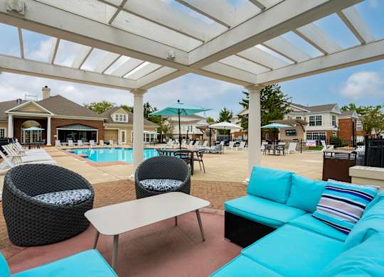 A white pergola over a patio with a pool in the background. at The Orchard, Dublin, Ohio