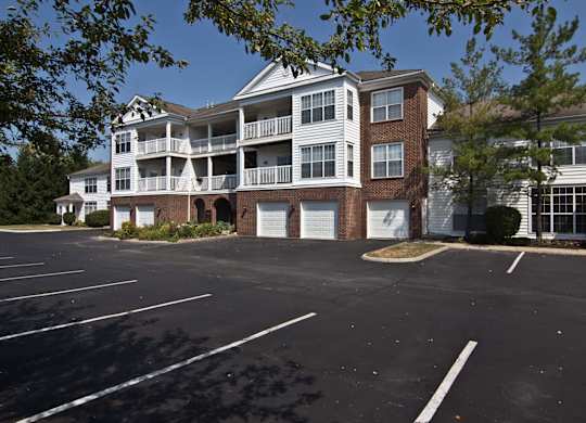 A parking lot in front of a two story apartment building. at The Orchard, Dublin, 43016