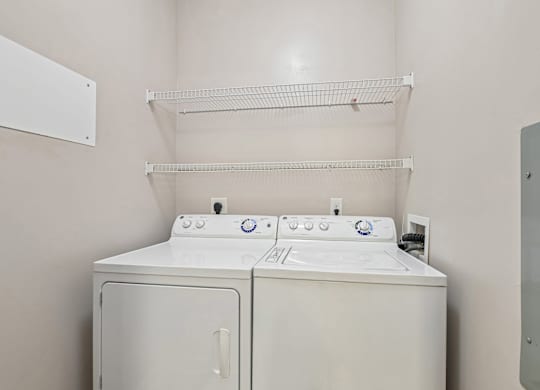 A white washing machine and dryer in a laundry room.