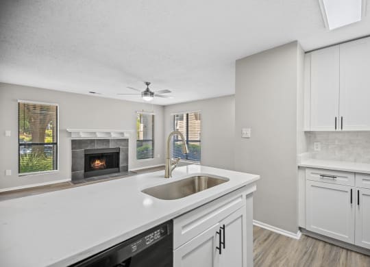 a white kitchen with a sink and a fireplace