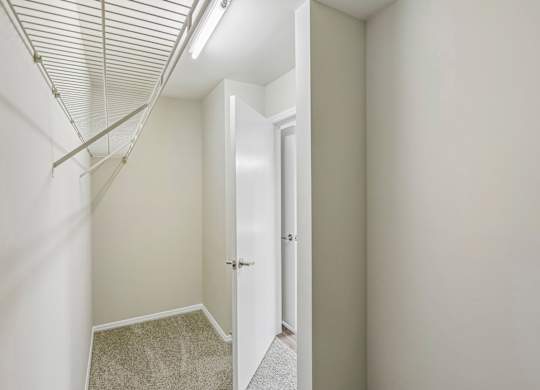 A hallway with a carpeted floor and a white door.