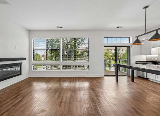 A modern living room with a fireplace and a view of the trees outside.